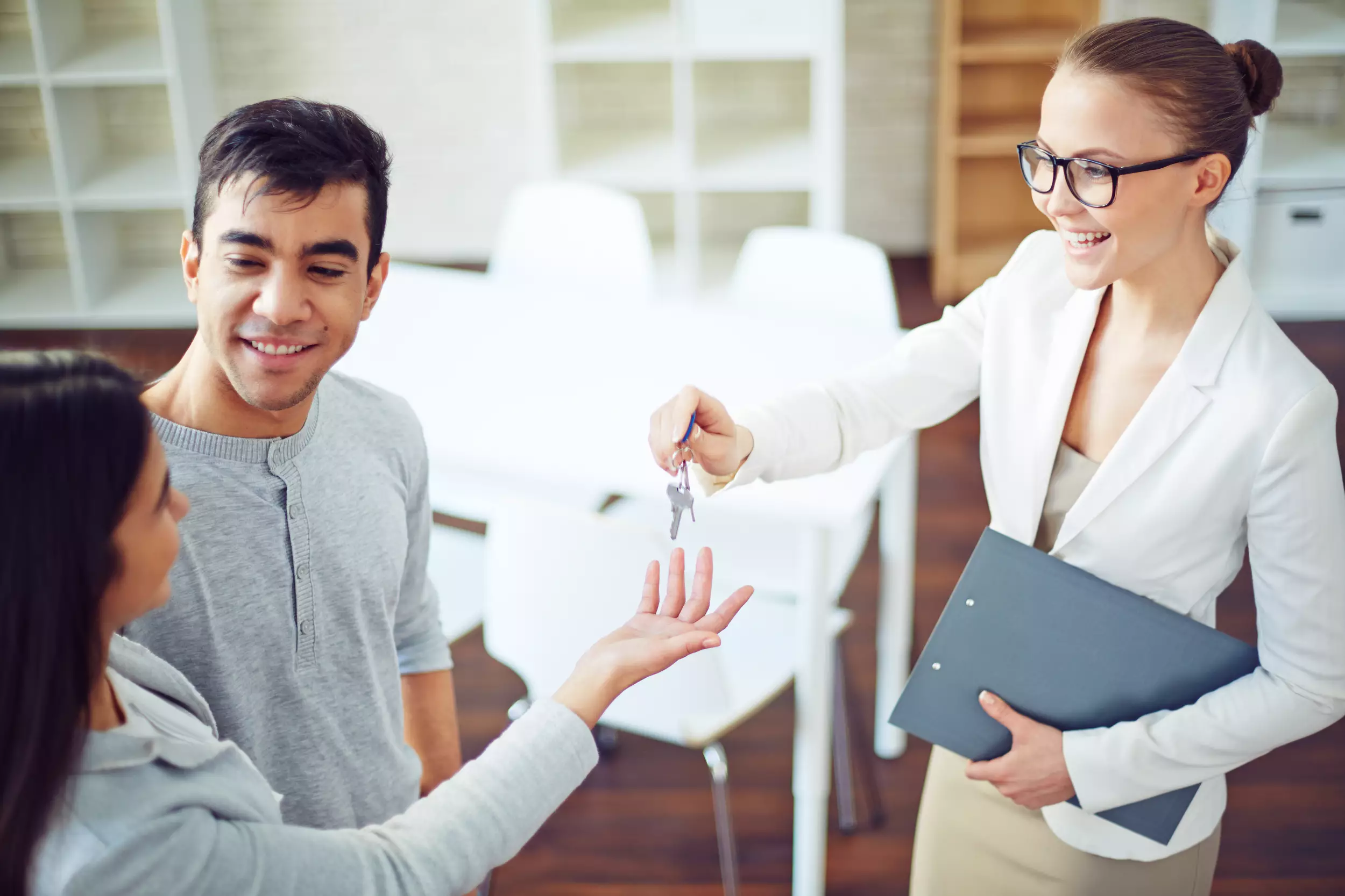 A young couple getting keys from a realtor